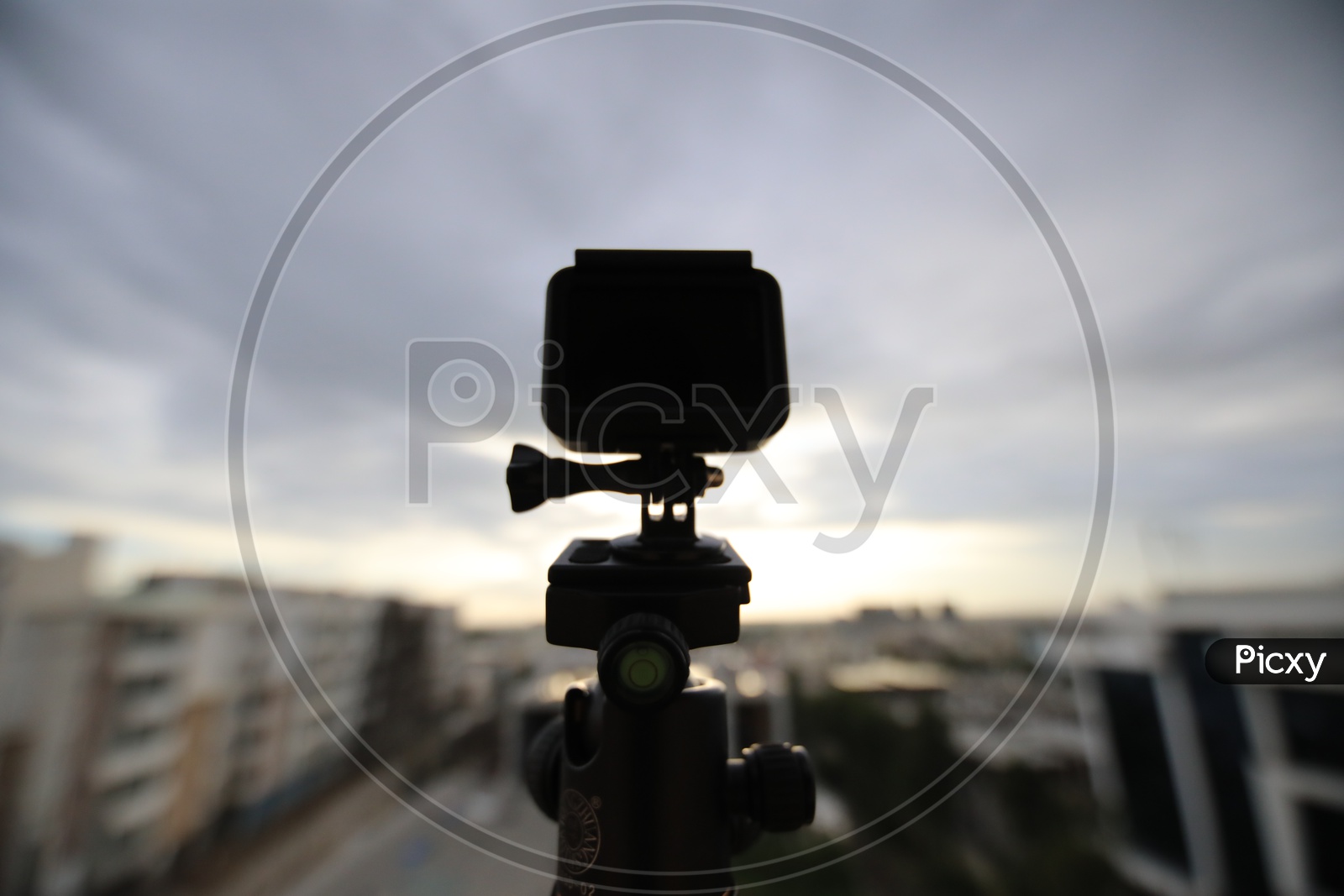 Silhouette Of a Go Pro Action Camera  Mounted To a Tripod To Shoot A City Scape