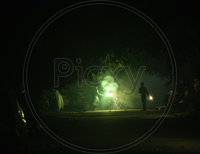 Silhouette Of a Man Celebrating Diwali By Firing Crackers In Streets