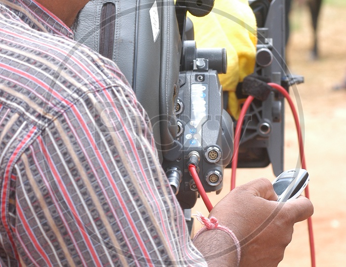 Movie Cameraman using Mobile while Shooting