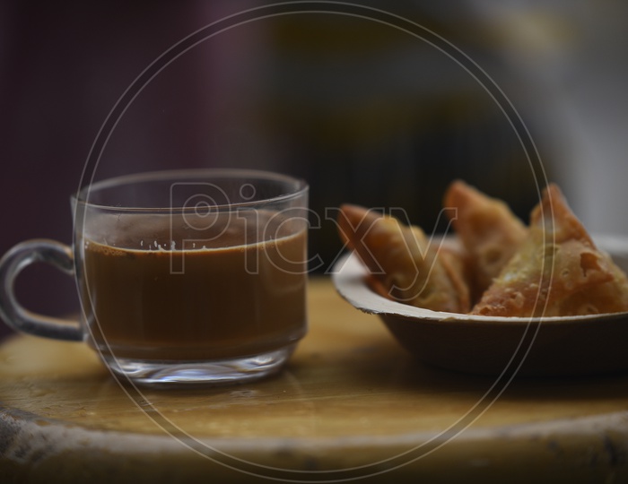 Hot Tea Served With Samosa At a Cafe Table