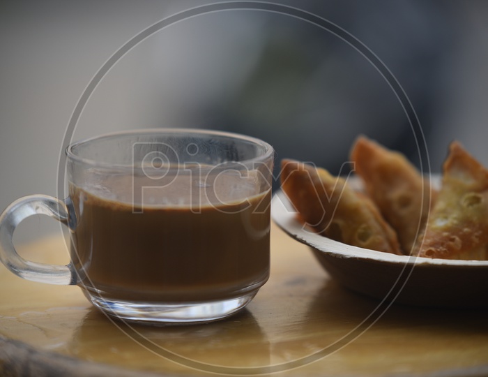 Hot Tea Served With Samosa At a Cafe Table