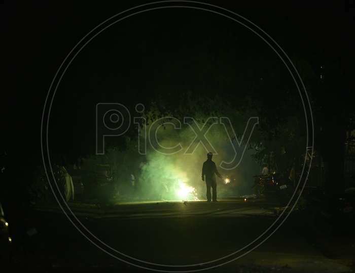 Silhouette Of a Man Celebrating Diwali By Firing Crackers In Streets