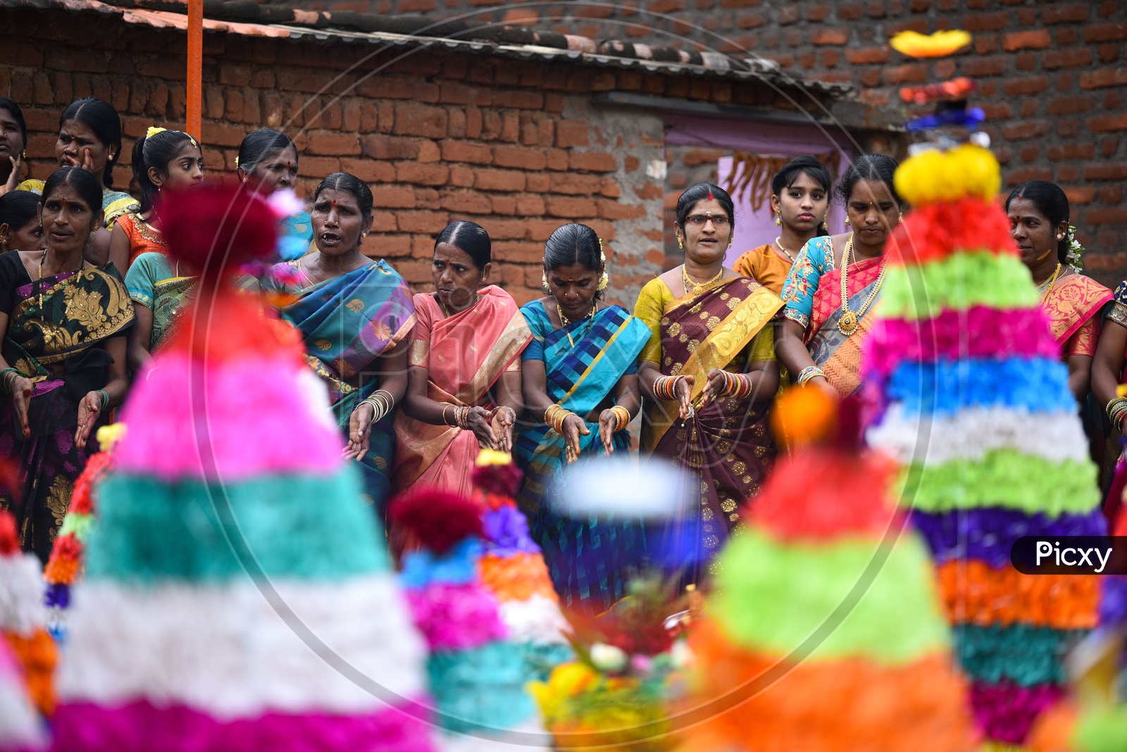 Women dance in front of flower arrangements made especially for Bathukamma, Telangana's most celebrated festival