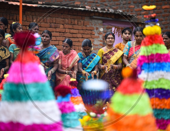 Women dance in front of flower arrangements made especially for Bathukamma, Telangana's most celebrated festival