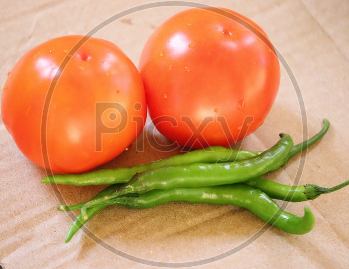 Red tomato and green chili pepper, essential vegetables for mexican food. - Image