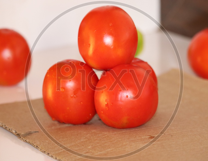 close up of fresh red delicious tomatoes on an old wooden tabletop background with place for text. Color toning. - Image