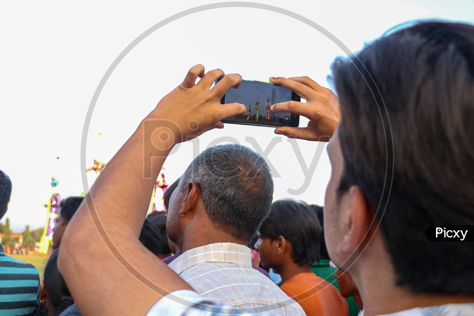 A young man taking photos of Ravan effigy during Dussehra celebration