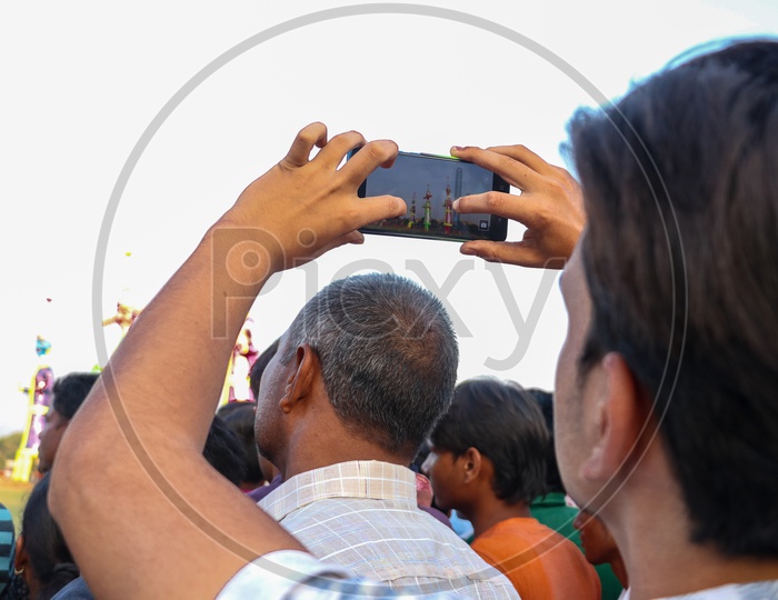 A young man taking photos of Ravan effigy during Dussehra celebration