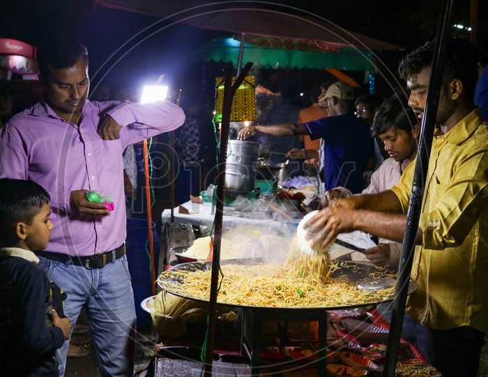 Vendor selling fast food noodles in a night market