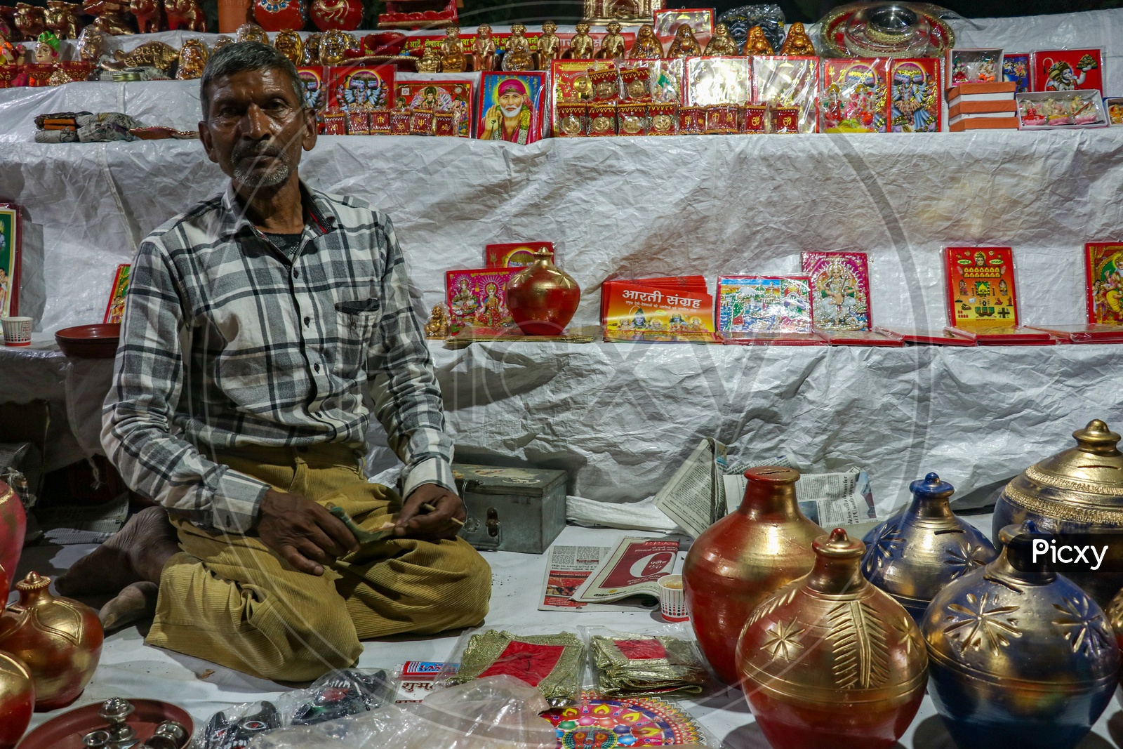 Street vendor selling photo frames of Hindu Gods and Goddesses and coin boxes