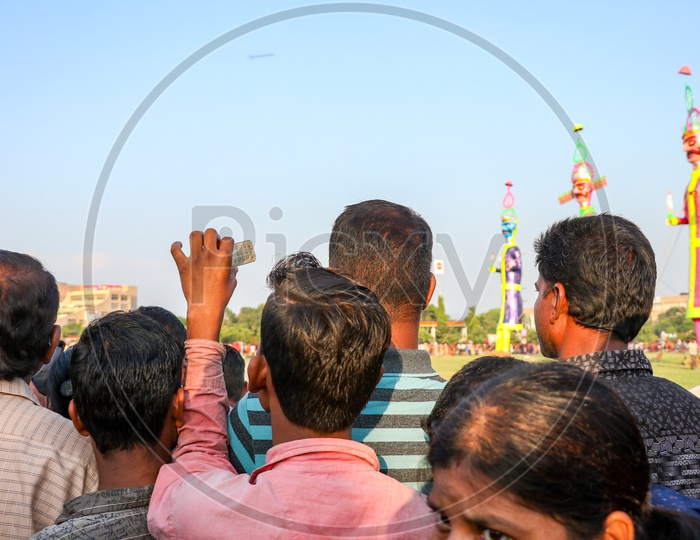 A young man taking photos of Ravan effigy during Dussehra celebrations