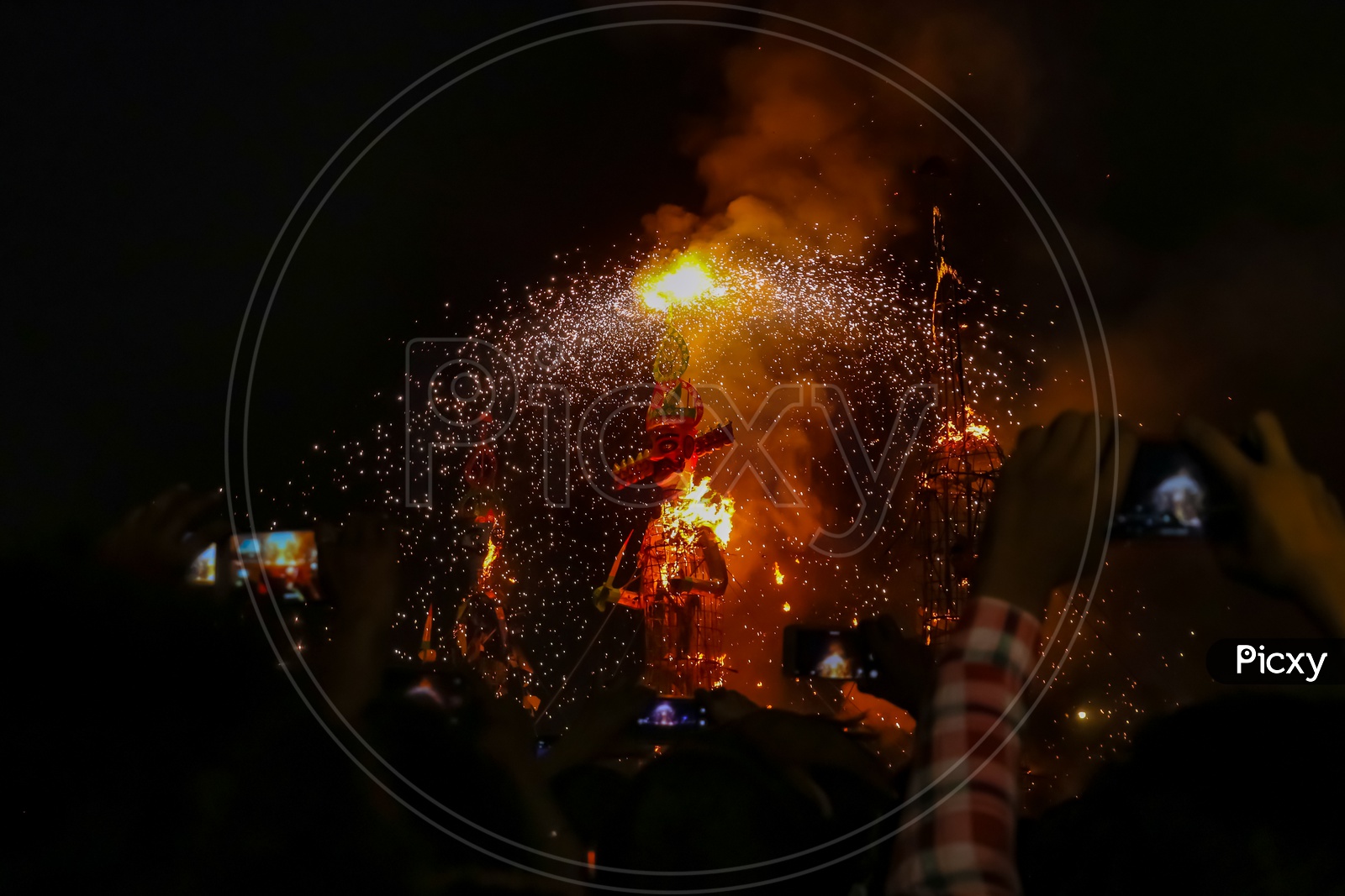 People taking photos of burning the effigy of Ravan during Dussehra festival