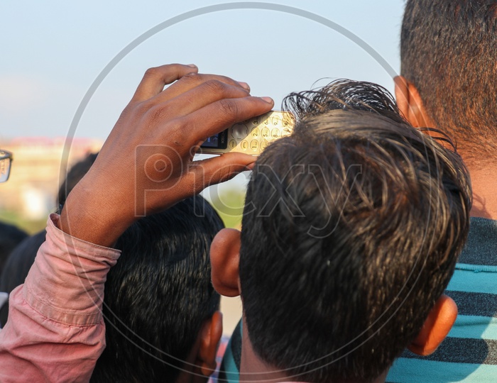 A young man taking photos of Ravan effigy during Dussehra celebrations