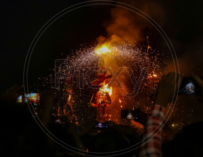 People taking photos of burning the effigy of Ravan during Dussehra festival