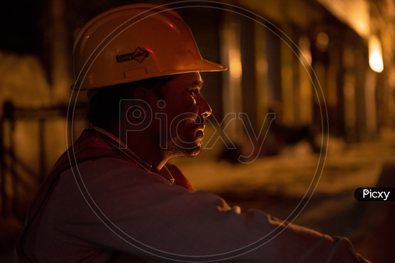 A Metro Construction Worker Sitting At a Work Place By Wearing Safety Helmet