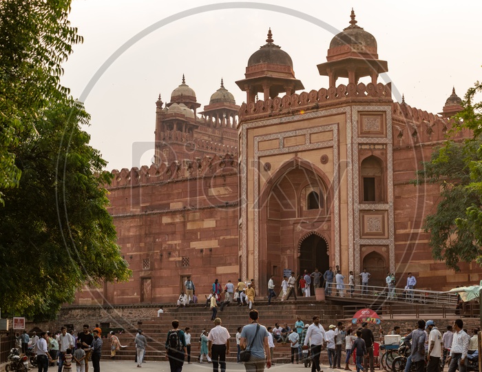 Tourists Or Visitors At Agra Fort With Fort Walls And Domes In Background