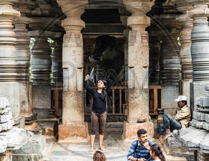 Young Indian  Woman Taking Selfie At Nandhi Statue in belur Chennakeshava Temple