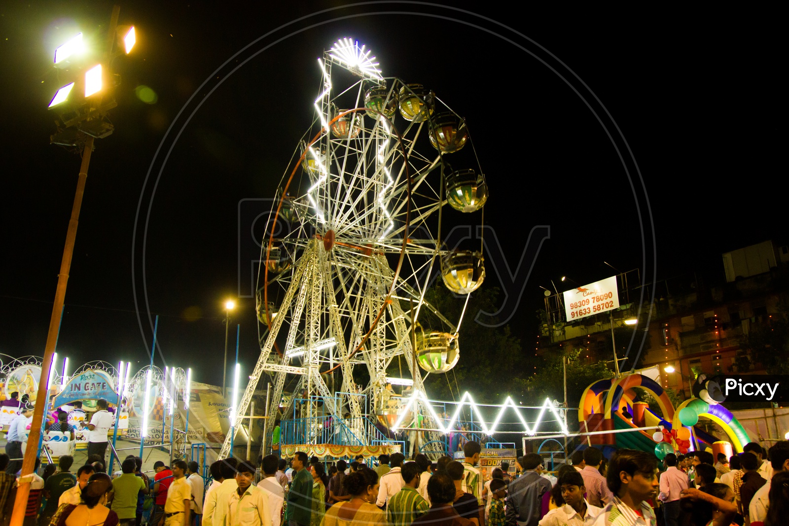 September, 2017,Kolkata,India. Visitors In A Park At Night Around A Giant Wheel During Durg Puja 2017 At Deshapriya Park