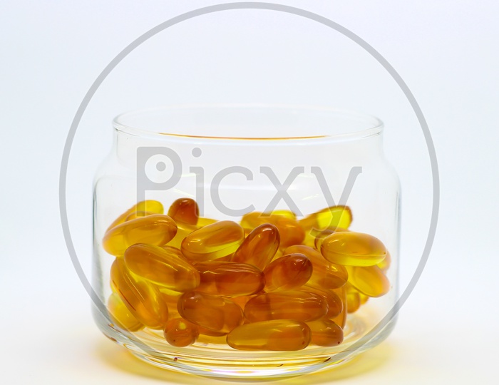Cod Liver Oil Omega 3 Vitamin E Gel Capsules Isolated On White Background In A Transparent Glass Bottle