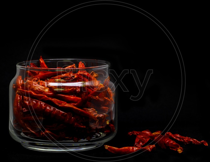 Dried Red Chilli In Glass Container In Black Background