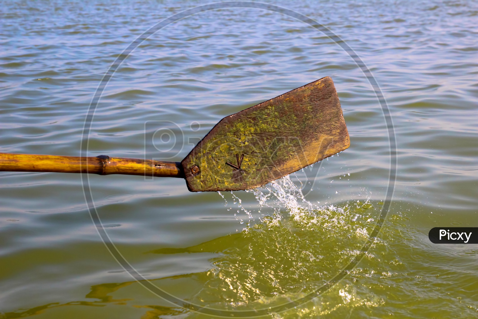 Wooden Oar Paddle Dipped In Water In A Rowing Boat Propelling Forward