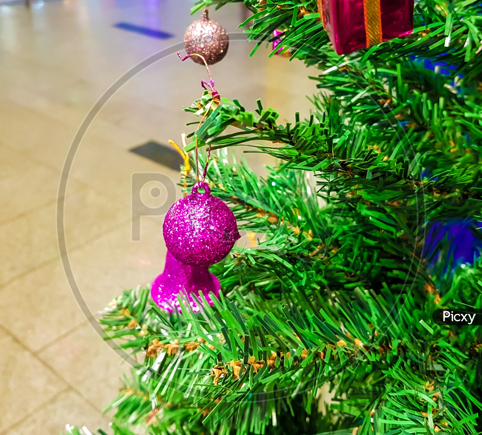Green Christmas Tree Decorated With Colurful Balls Bells And Gift Boxes