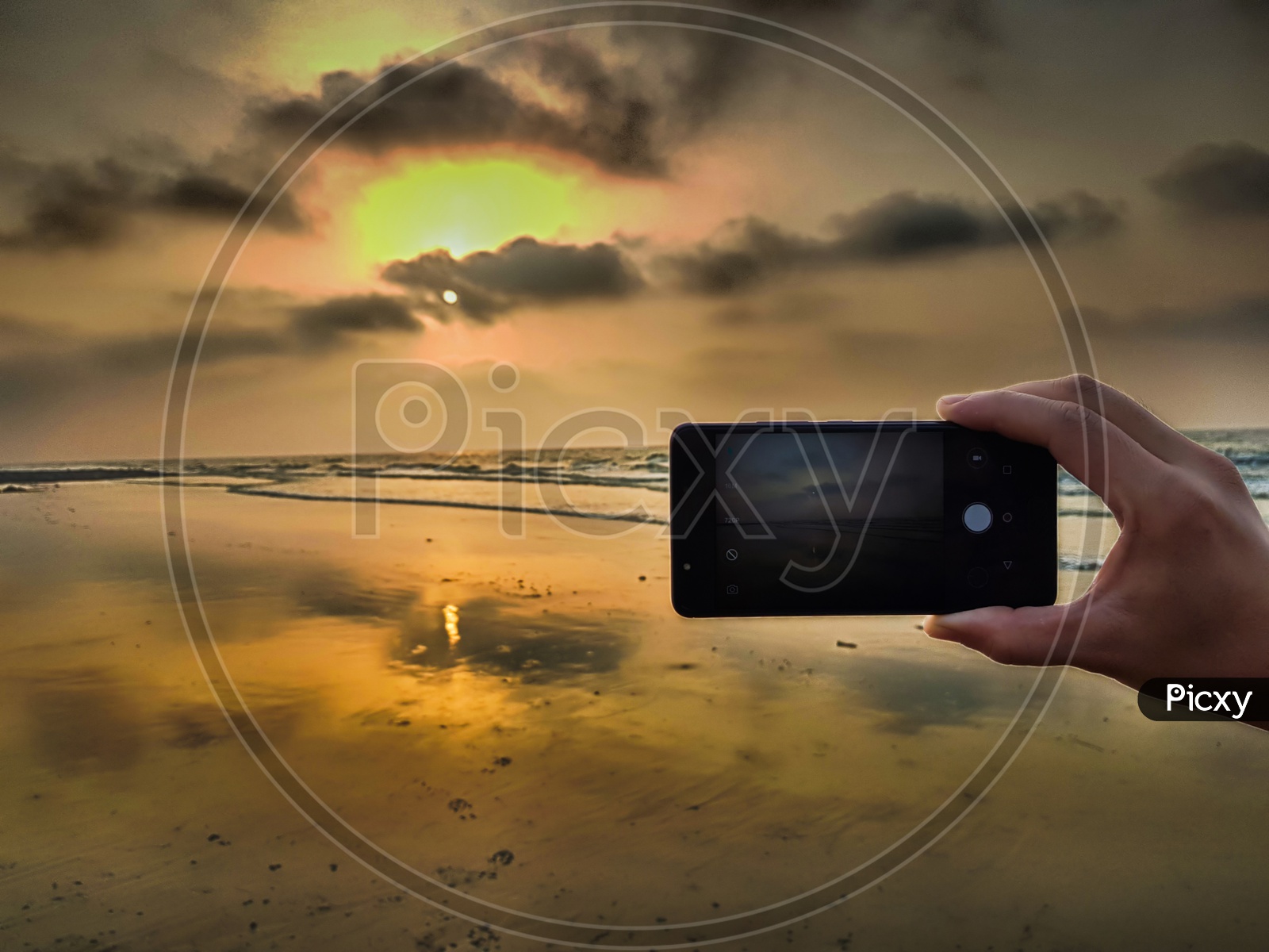 Hand Taking Photo Of A Beach Sunset With Smartphone