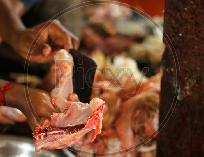 Butcher Cutting Chicken On A Standing Blade Dao With Hand For Sale