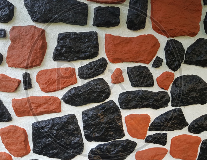Texture Of Black Stones Over A White Wall With Patterns Forming a Background