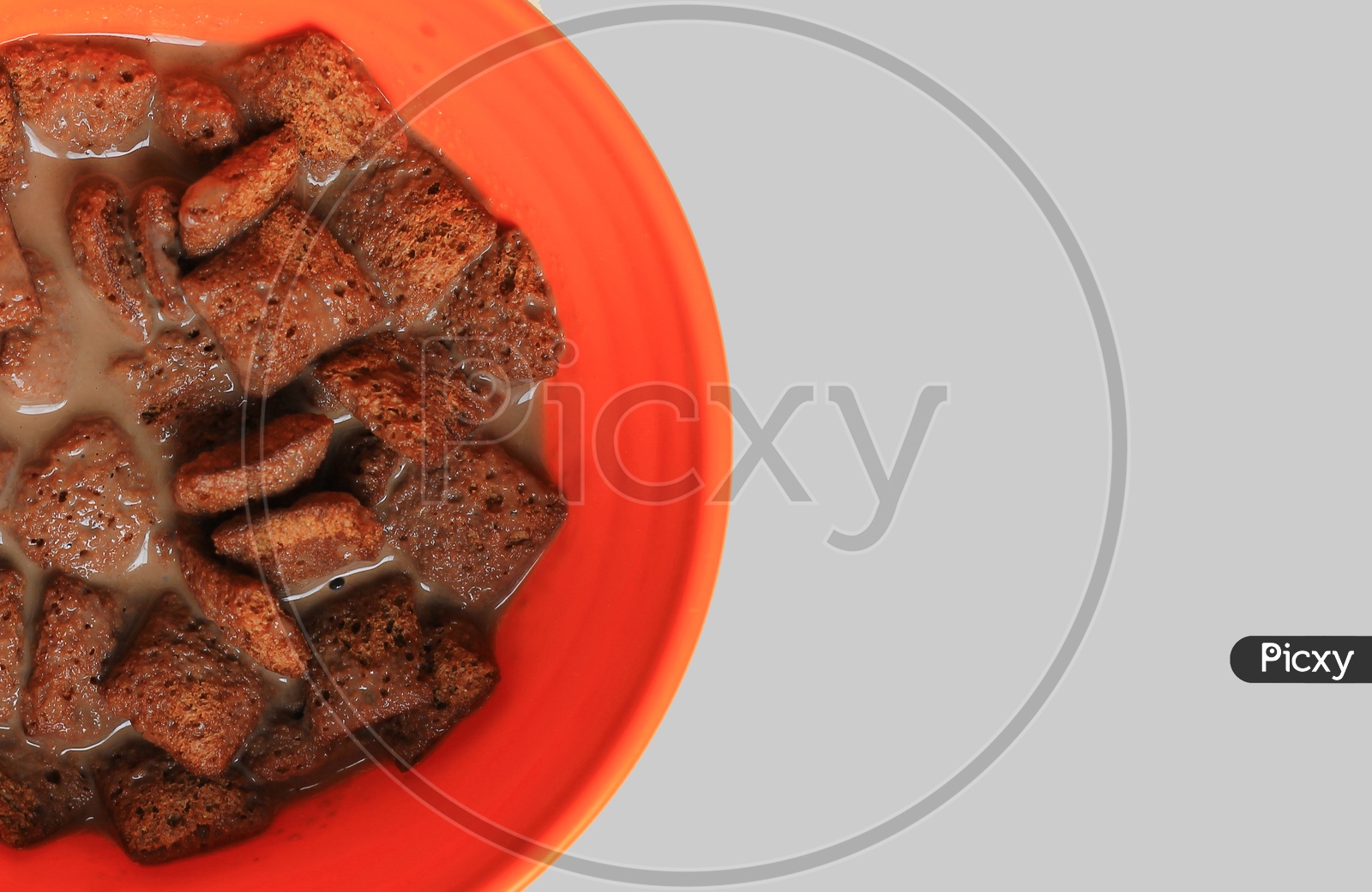 Chocolate Filled Cookies Dipped In Chocolate Milk On An Orange Bowl In Light Background