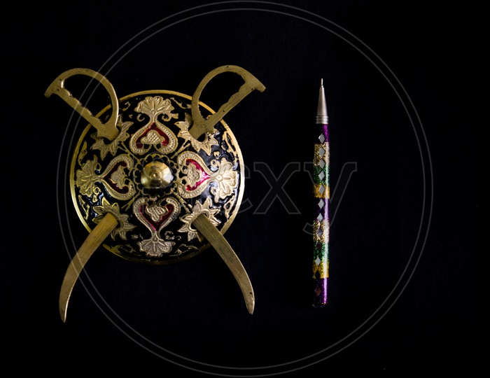 Decorated Round Sword And Shield And Pen Isolated In Black Background With Copy Space For Text.Antique Artefact