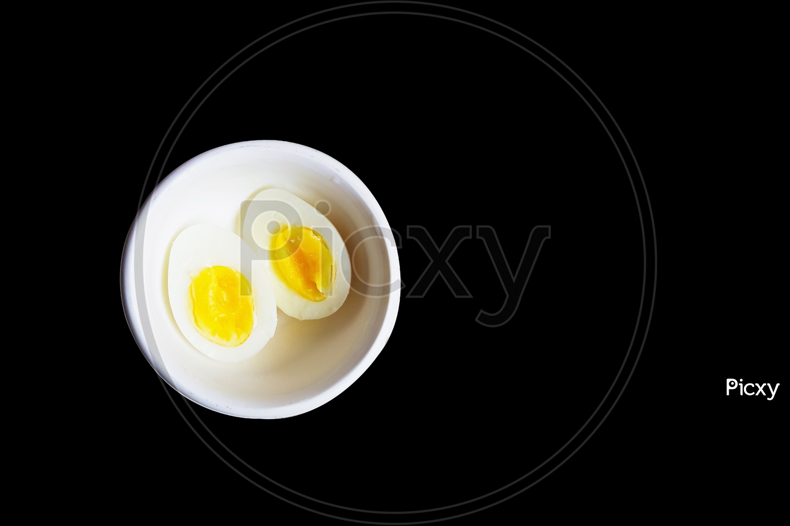 Boiled Egg Cut In Half In A White Bowl In Black Background With Space For Text