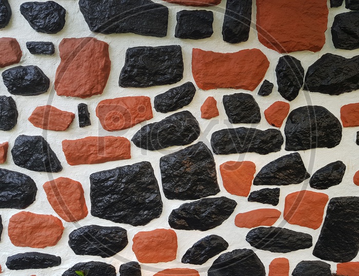 Texture Of Black Stones Over A White Wall With Patterns Forming a Background
