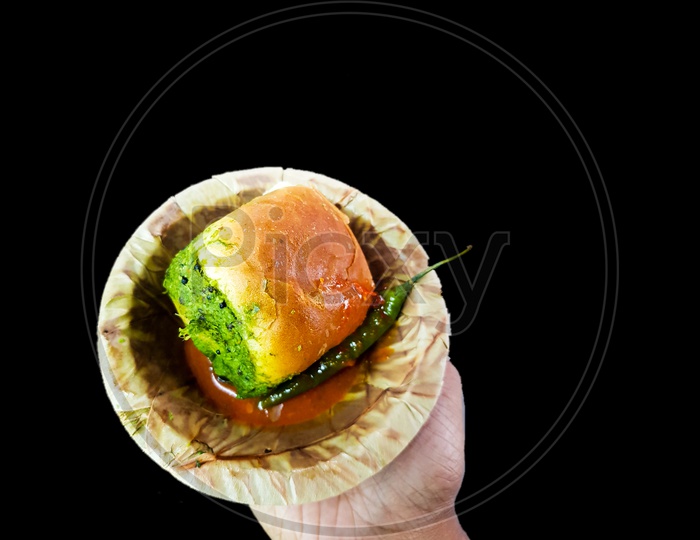 Vada Pau Bread And Green Sauce On A Plate In Dark Background On Hand