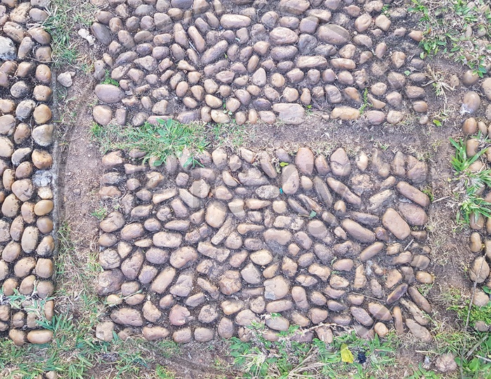 Texture Background of Stone Pebbles Brick On a Foot Path Forming a Background