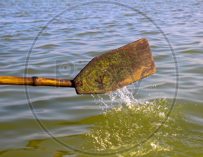 Wooden Oar Paddle Dipped In Water In A Rowing Boat Propelling Forward