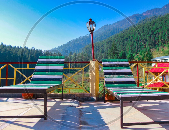 Resting Wooden Easy Chair With Himalayan Hills In Background With Blue Skies During Runrise
