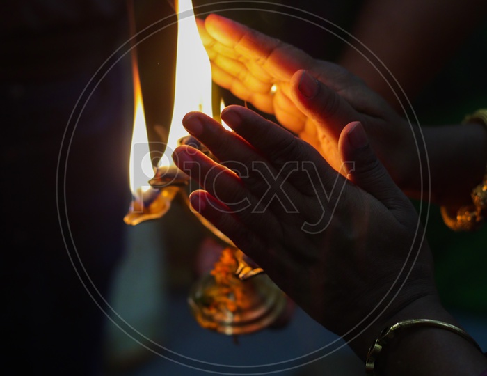 Hands Taking Warmth Of Divine Diya Holy Flame Of Hindu God Worship Puja For Blessings