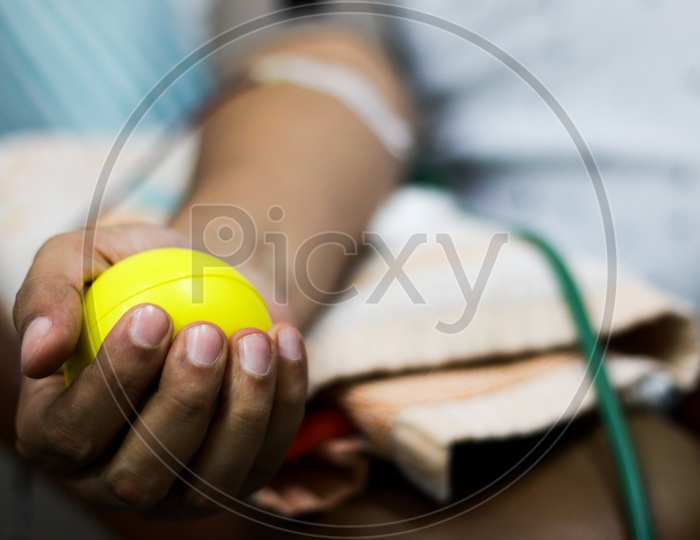 Selective Focus Of Blood Collection During Blood Donation And Ball In Palm For Squeezing