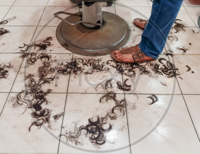 Dirty Floor Of A Hair Salon With Hairs On Floor In Barber Shop