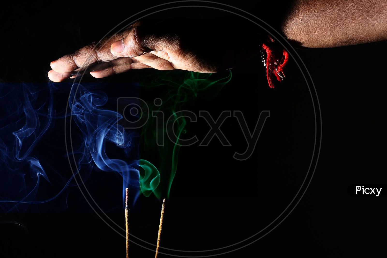 Hand Over Coloured Smoke Coming Out Of Incense Sticks. Abstract Smoke Art