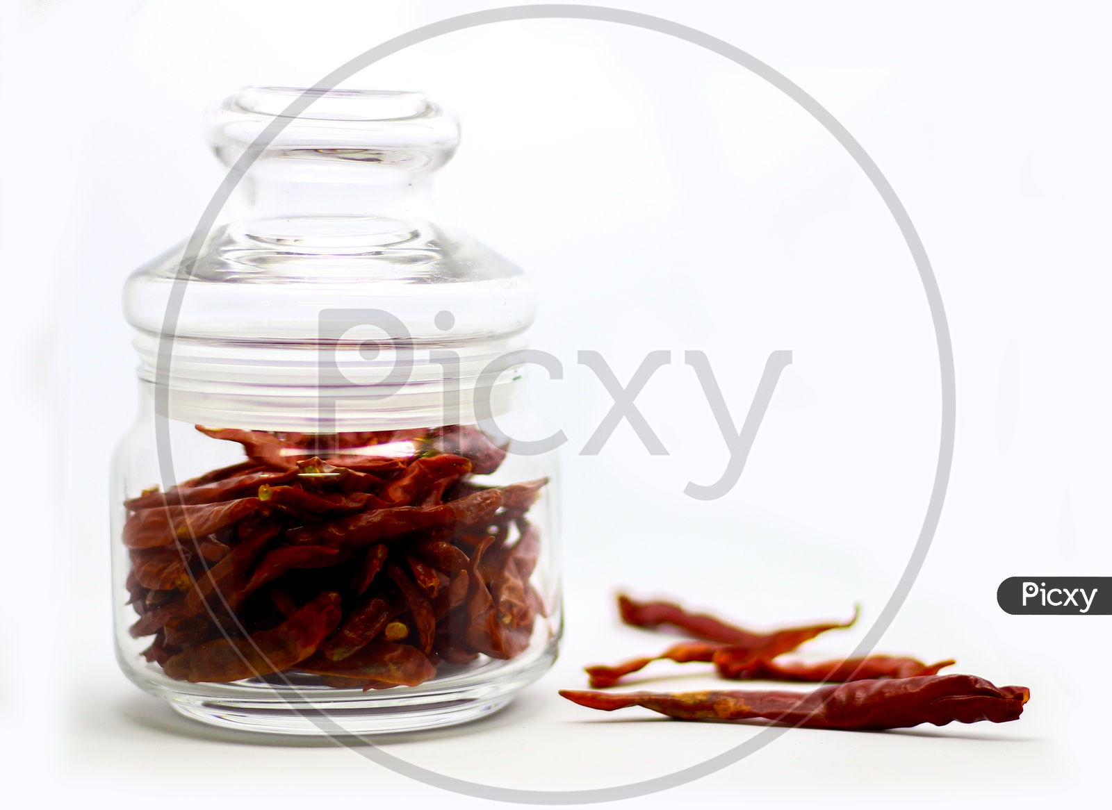 Dried Red Chilli In Glass Container In White Background