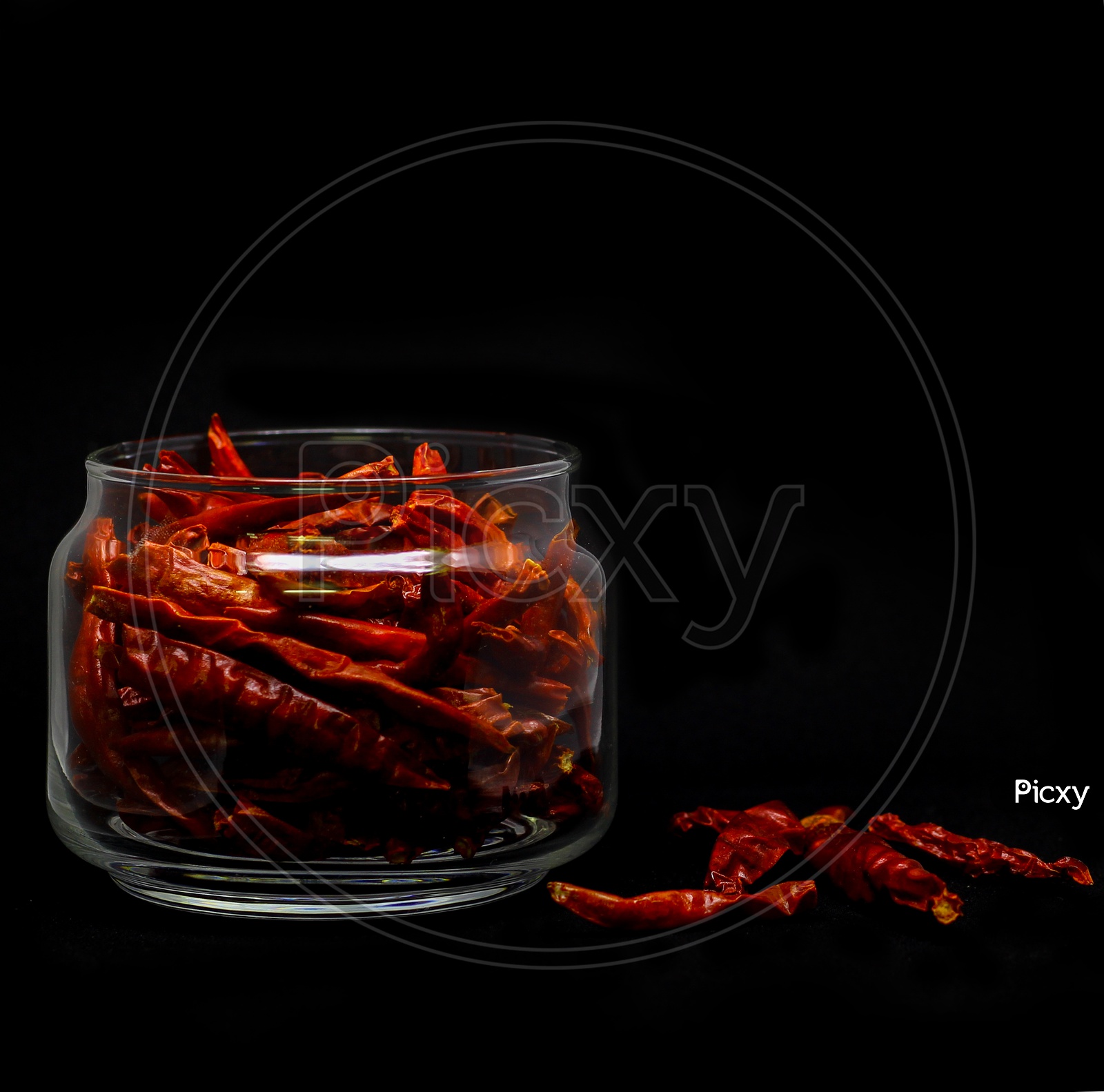 Dried Red Chilli In Glass Container In Black Background