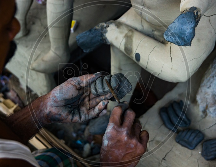 Kumartuli,West Bengal, India, July 2018.An Artisan Working On Shaping The Hand Of A Clay Idol Of Goddess Durga At A Shop During Night. Durga Puja Is The Most Awaited Hindu Festival In Eastern India And Worldwide.