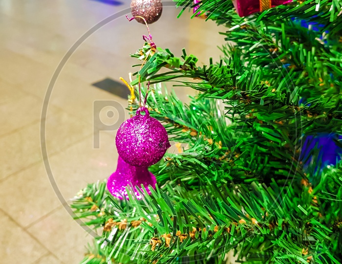 Green Christmas Tree Decorated With Colurful Balls Bells And Gift Boxes