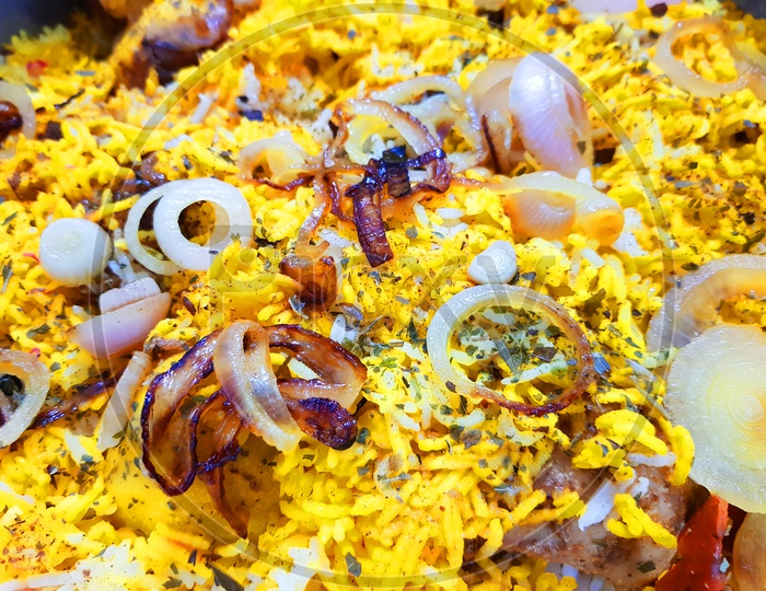 Close Up Photo Of Hyderabadi Dum Handi Biryani Garnished With Onions