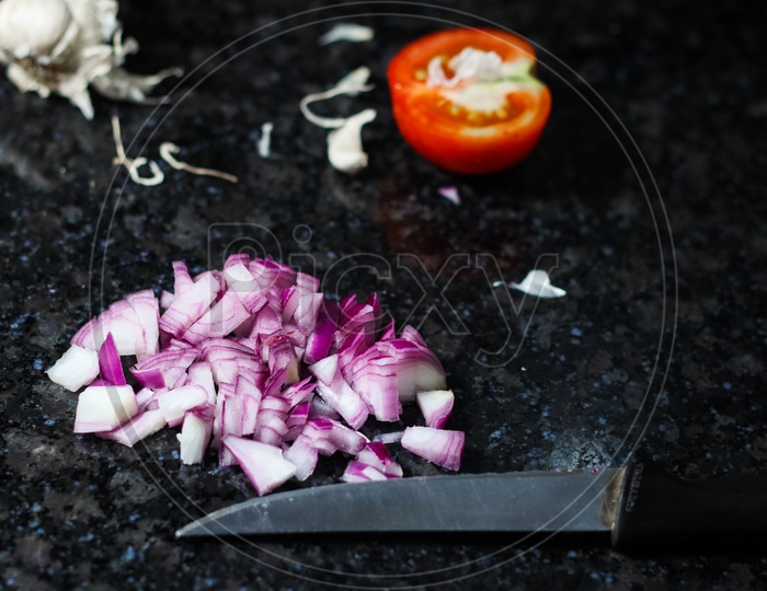 Finely Chopped Onion And Tomato And Knife On Granite Background