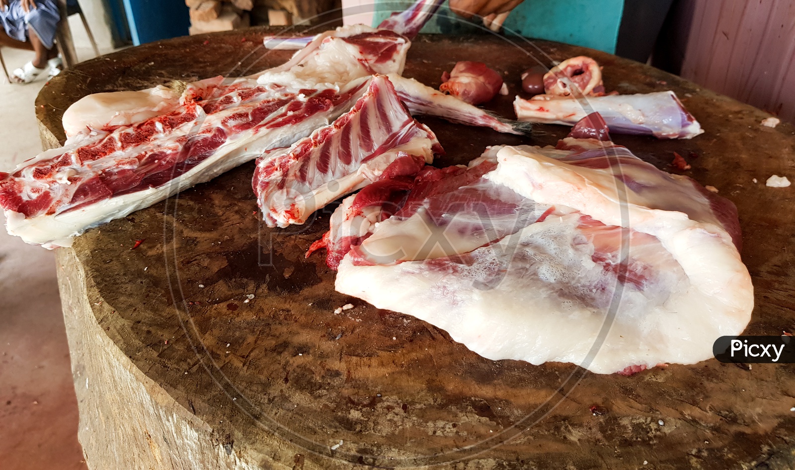 Fatty Red Meat Cut Manually On A Wooden Platform By A Butcher With A Meat Copper Knife