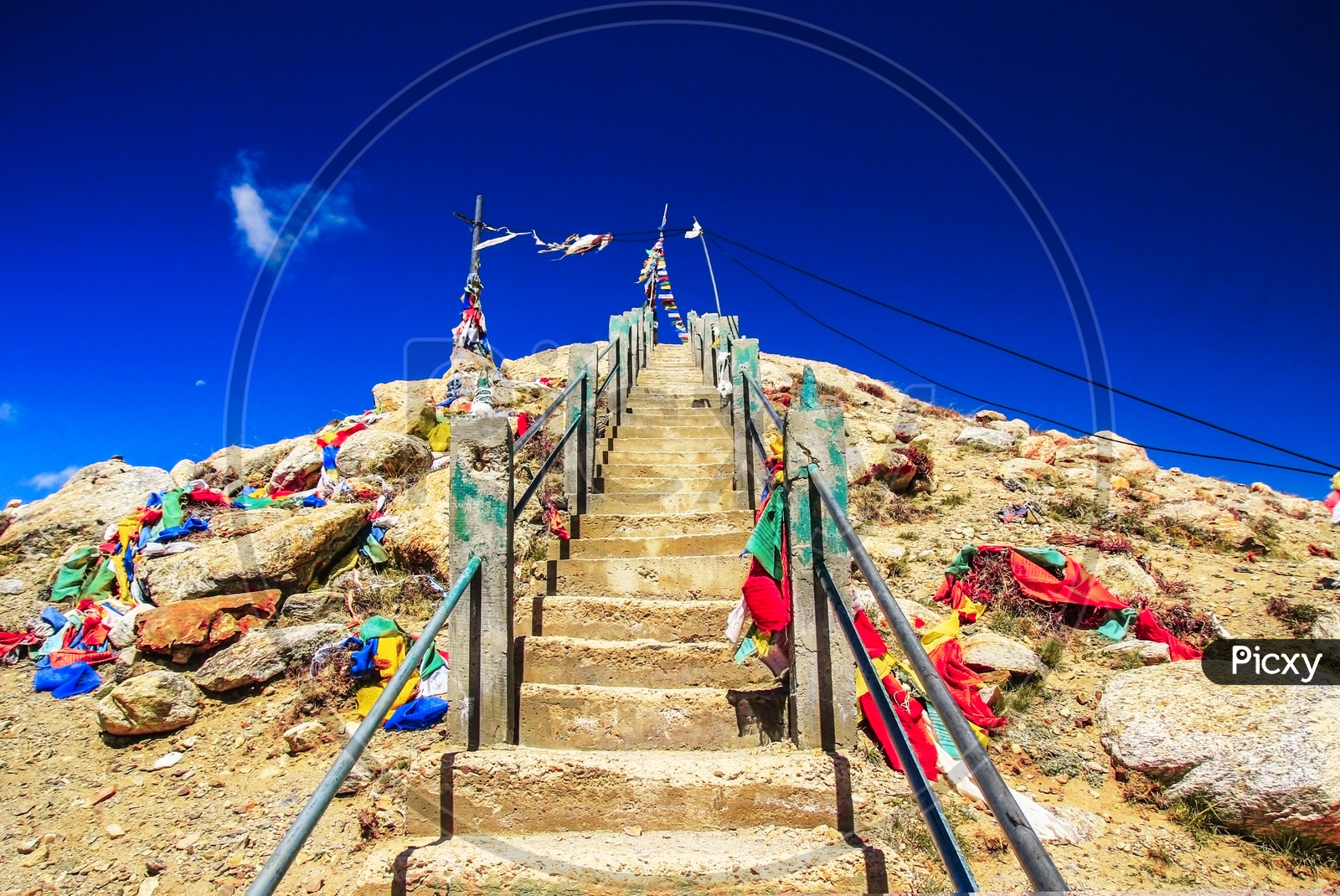 Steep Rock Stairs With Colourful Flags Rising Up With Deep Blue Sky