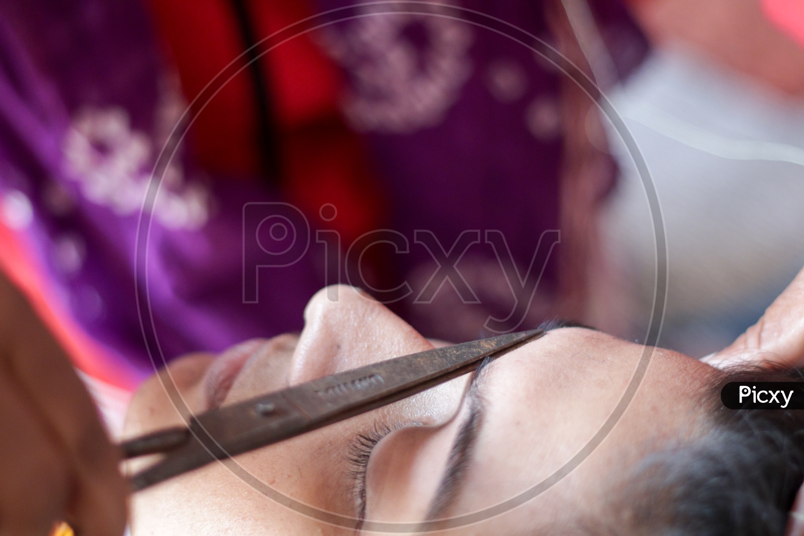 shaping and plucking of eye brow with threading. epilation cosmetic procedure in beauty parlour.
